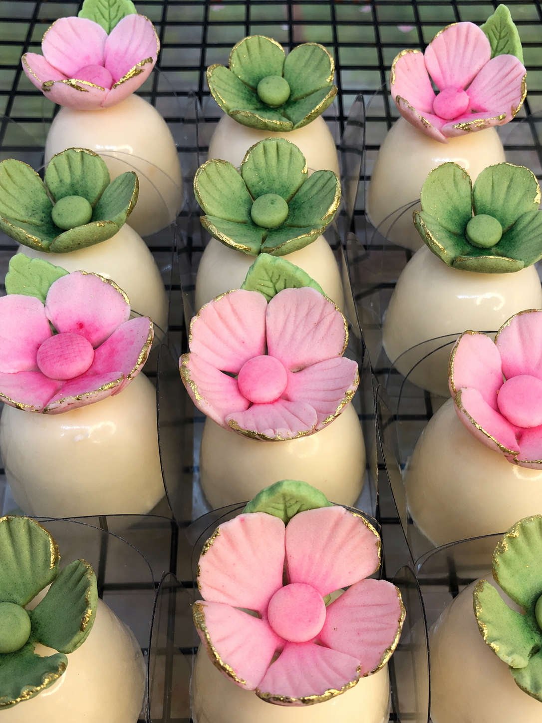 Bombons decorados com apliques florais rosa e verde com acabamento dourado